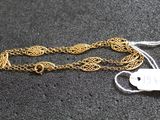 a close up of a gold chain with a tag on it