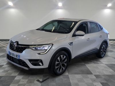 a white car is parked on a checkered floor in a showroom