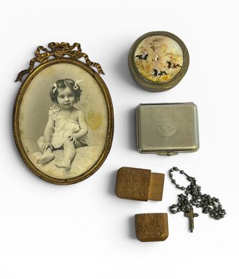 la photo d'une petite fille dans un cadre, à côté d'autres objets