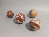 four marble balls sitting on top of a table next to each other