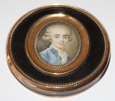 portrait of a man in a blue coat in a gold - plated box