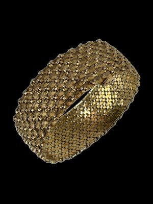 gros plan d'un bracelet en or sur fond noir
