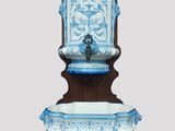 a blue and white water fountain on a wooden stand