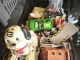 a toy dog sitting in a suitcase with other toys