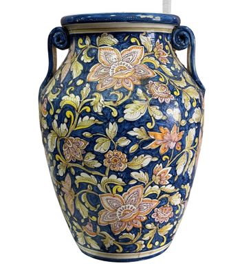 un vase muni d'une anse ornée d'un motif floral