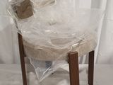 a plastic chair wrapped in plastic and sitting on a white surface