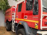 un camion de pompiers rouge garé devant un immeuble
