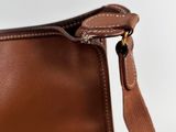 a close up of a brown leather bag with a strap