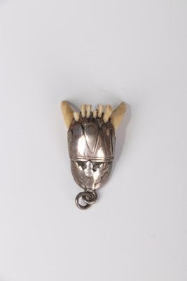 a small metal object with horns on a white surface