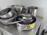 de nombreuses casseroles et poêles posées sur une table en métal