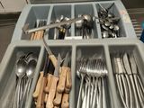 de nombreuses cuillères, fourchettes et cuillères dans un plateau