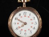a close up of a gold pocket watch on a black surface