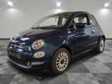 La petite voiture bleue est garée dans le garage, sur le sol à damier.