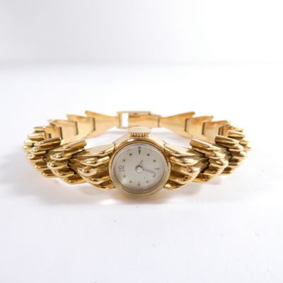 an image of a woman ' s wrist watch on a gold bracelet