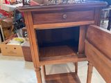 a small wooden table with a drawer on top of it