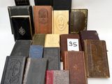 several old books are stacked on top of each other on a white surface