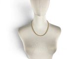 the mannequin has a gold chain on it ' s neck