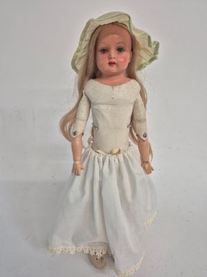 a doll that is wearing a white dress and a hat