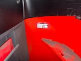 a red seat in the back of a bus with the door open