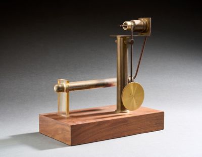 une image représentant une maquette de machine à vapeur posée sur un socle en bois