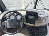 a steering wheel and dashboard of a bus on the street