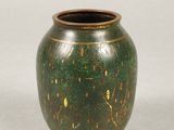 a green vase sitting on a table with a white background