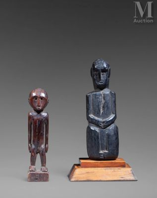 deux statues en bois représentant un homme et une femme debout l'un à côté de l'autre