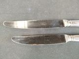 two knives that are sitting next to each other on a table