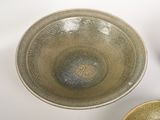 three bowls sitting on a white table with a black bowl next to them