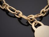 un gros plan d'une chaîne en or à laquelle est accroché un cadenas