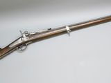 un vieux fusil avec un canon en bois et une poignée en métal