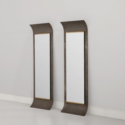 deux miroirs dans une pièce aux murs et au sol blancs