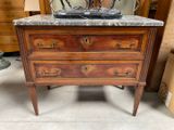 une commode au plateau en marbre, placée au milieu d'une pièce