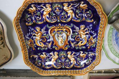 une assiette bleue et dorée sur laquelle est représentée une femme