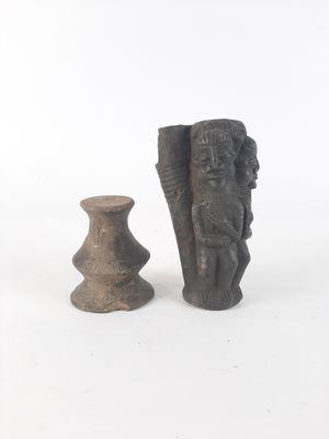 two pieces of pottery sitting next to each other on a white surface