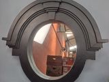 a round mirror on the wall with a reflection of a building in it