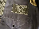 the back of a black jacket with a gold label on it