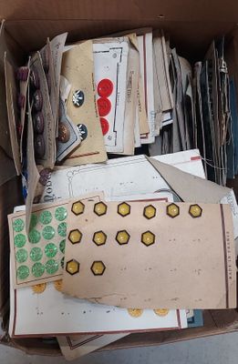 une boîte en carton remplie d'une multitude de papiers et d'autocollants