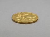 a close up of a gold coin on a white surface