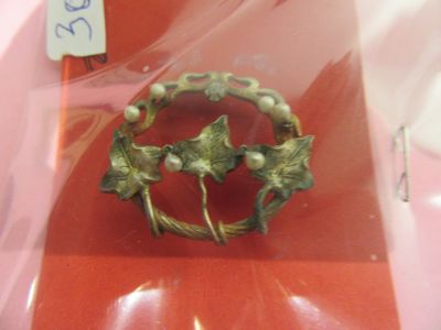 une broche en or ornée de feuilles et de perles