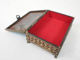 a small metal box with a red lid on a white surface