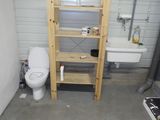 une salle de bains équipée de toilettes, d'un lavabo et d'une étagère