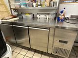 a stainless steel counter in a kitchen with a trash can