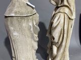 two statues of women in robes are standing next to each other