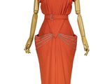 an orange dress on a mannequin stand with a white mannequin
