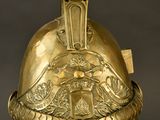 casque plaqué or orné d'un aigle et d'un bouclier, posé sur un socle, sur fond noir