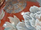 a vase with flowers painted on it sitting on a table