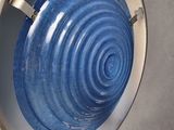 a blue bowl sitting on top of a metal stand
