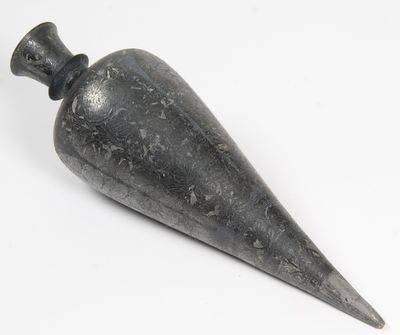 une image représentant un objet en pierre noire posé sur une surface blanche