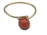 a close up of a gold ring with a red stone on it